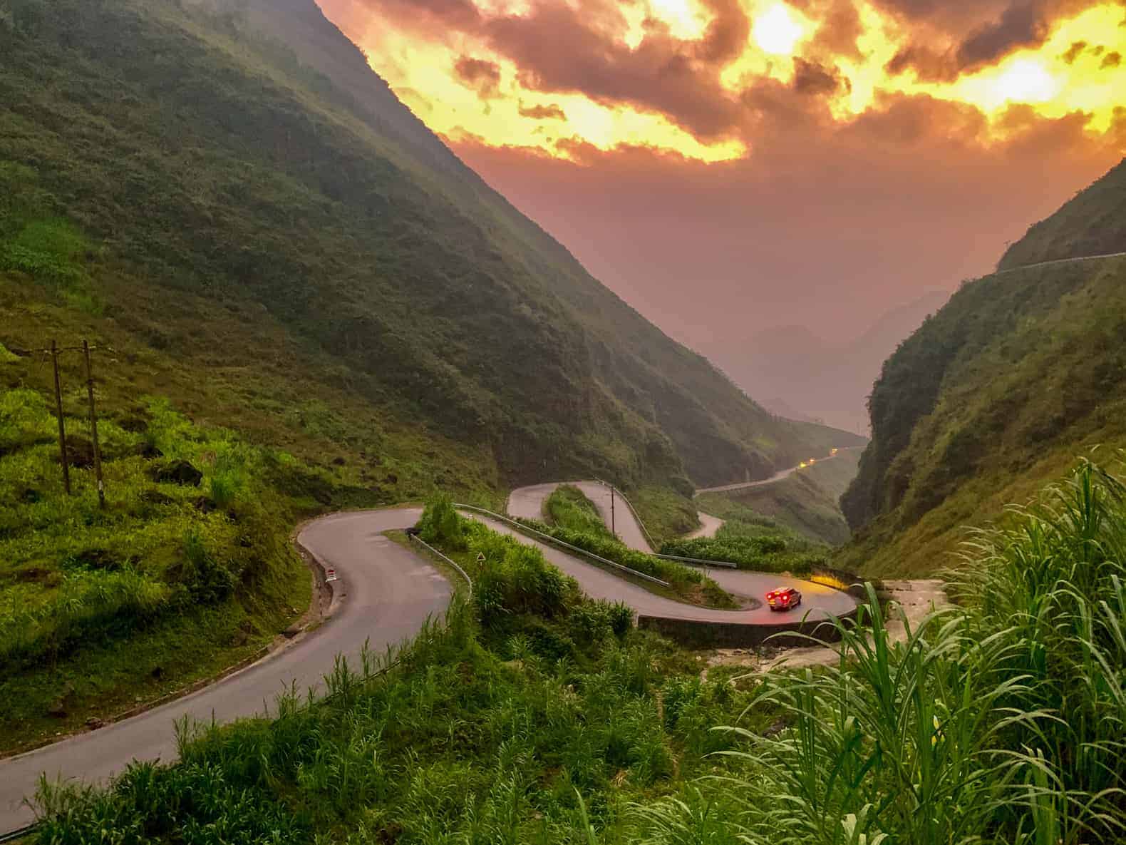 A windy road near Dong Van Karst Plateau on the Ha Giang Motorbike loop at sunset in North Vietnam Highlands.
