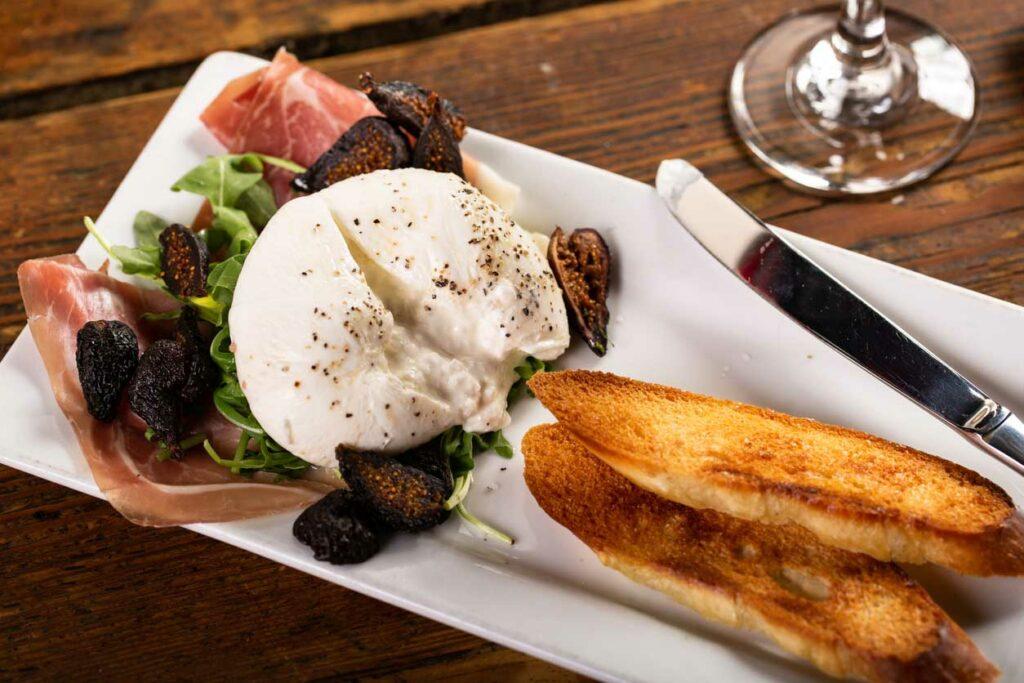 Burrata is a cheese popular in Rome normally serveed with a vegetable like tomato or fruit like fig, can be eaten with bread and often served with prosciutto or jamon